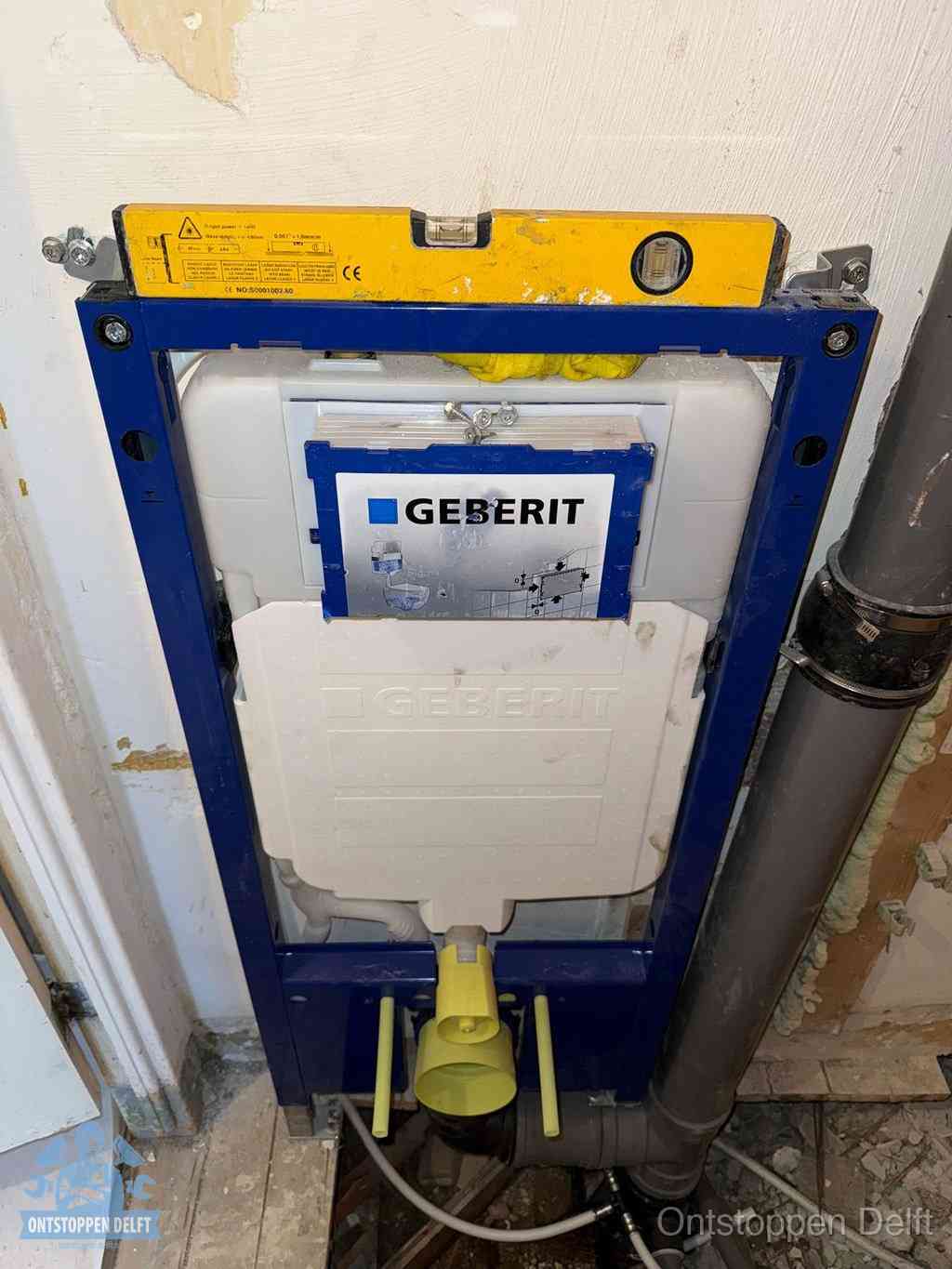 Een Geberit inbouwreservoir met frame voor een hangtoilet tegen de wand, met de afvoerbocht naar de vloer, kenmerkend voor een verstopt hangtoilet in Delft