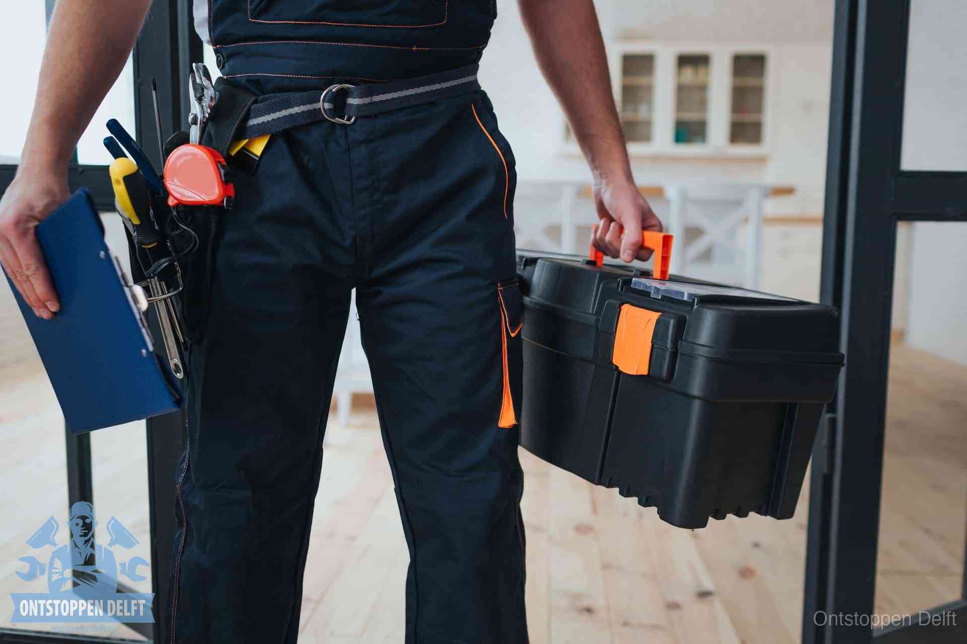 Een monteur met gereedschapsriem en klembord in een keuken, klaar om een transparante prijs voor het gootsteen ontstoppen in Delft te geven