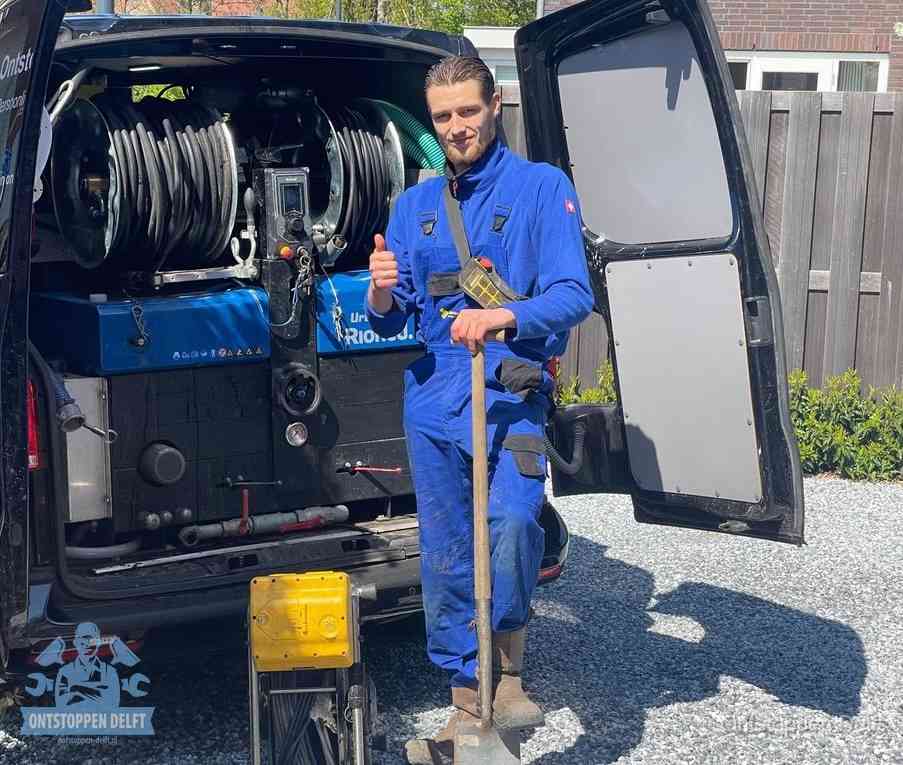 Monteur met duim omhoog bij de rioolreinigingsbus, duidelijke kosten voor riool ontstoppen in Delft