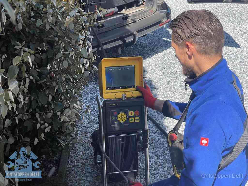 Monteur bedient een rioolinspectiecamera met monitor voor rioolinspectie in Delft