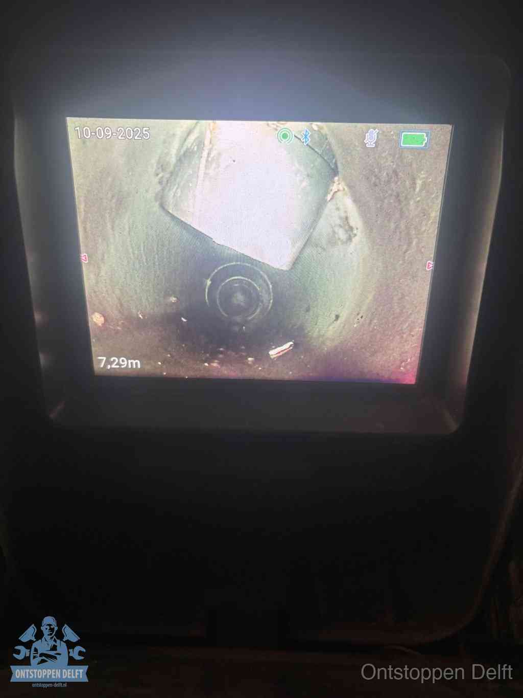 Camerabeeld van een verzakte rioolbuis diep onder de grond, een rioolverzakking in Delft