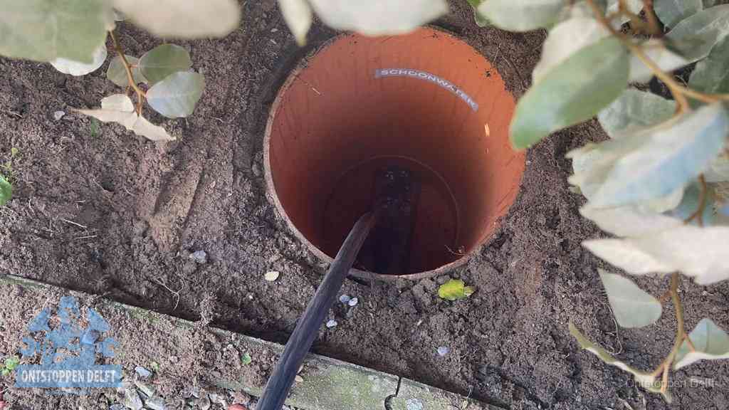 Open inspectieput in de tuin waar een veer rioolvliegjes en stankoverlast aanpakt in Delft