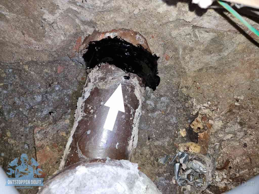 Een oude gres rioolbuis met een beschadigde koppeling onder de vloer, oorzaak van terugkerende structurele wc-problemen in Delft