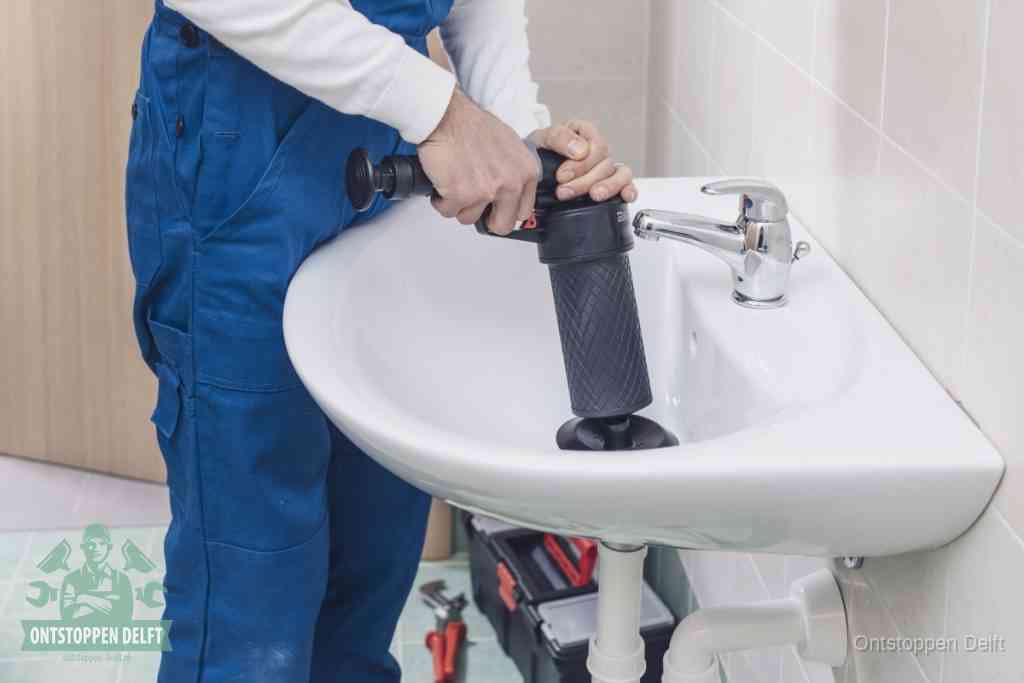 Een te ruwe doe-het-zelf poging met een hand-pomp op de afvoer van een badkamer-wastafel, een van de veelgemaakte fouten bij afvoer ontstoppen in Delft